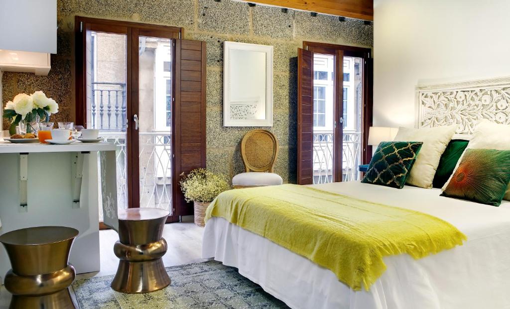 a bedroom with a large bed with a yellow blanket at Numa Rúa Travesa in Santiago de Compostela