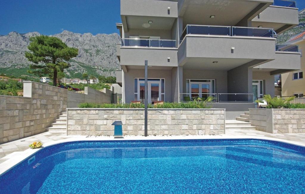 une maison avec une piscine en face d'une maison dans l'établissement Villa EM, à Makarska