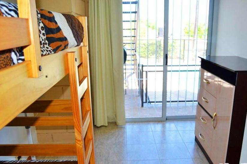 a room with a bunk bed and a dresser and a sliding door at Malaquias in Villa Carlos Paz