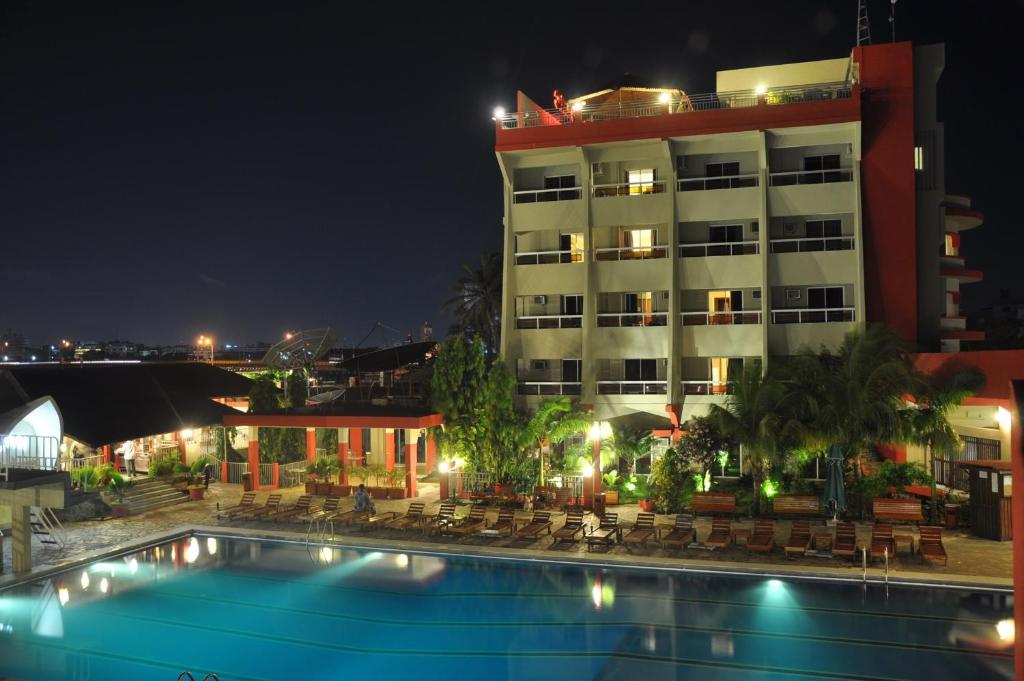 a hotel with a swimming pool at night at Hotel Du Lac in Cotonou