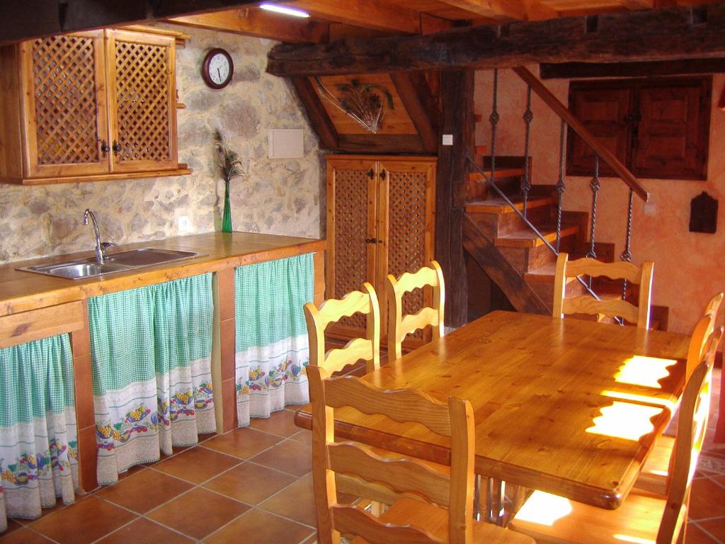 comedor con mesa de madera y fregadero en Casa El Carrelu, en Póo