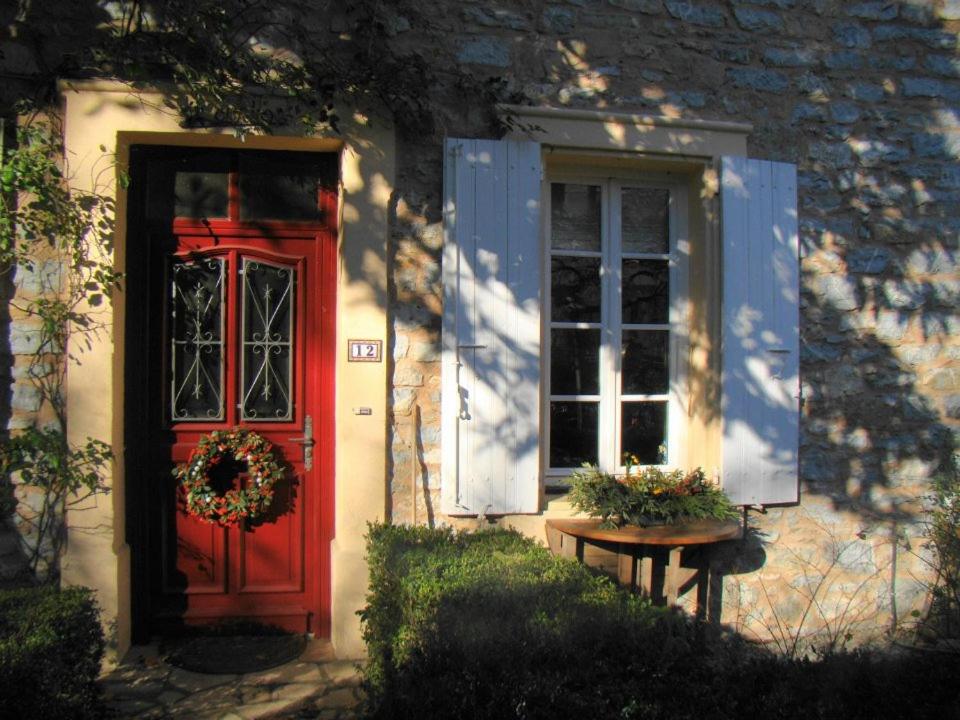 una puerta roja y una ventana en una casa en l'Oulibo, en Villeneuve-les-Corbières