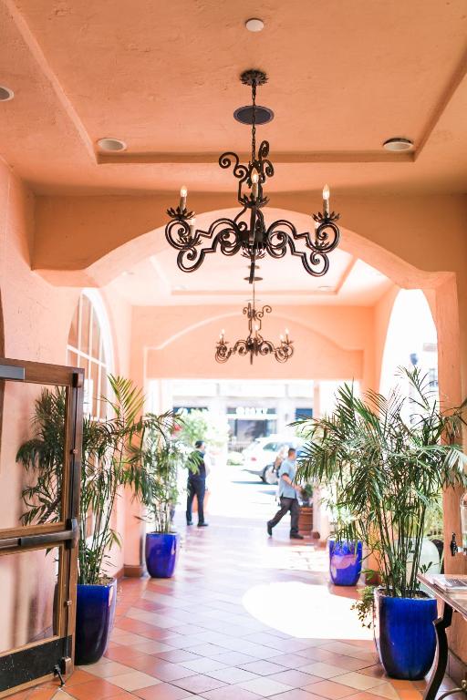 a chandelier in a hallway with potted plants at La Valencia Hotel in San Diego