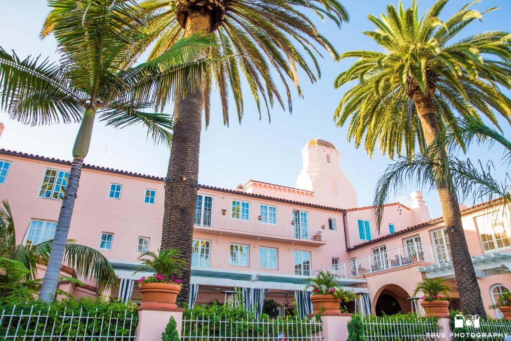 a pink building with palm trees in front of it at La Valencia Hotel in San Diego