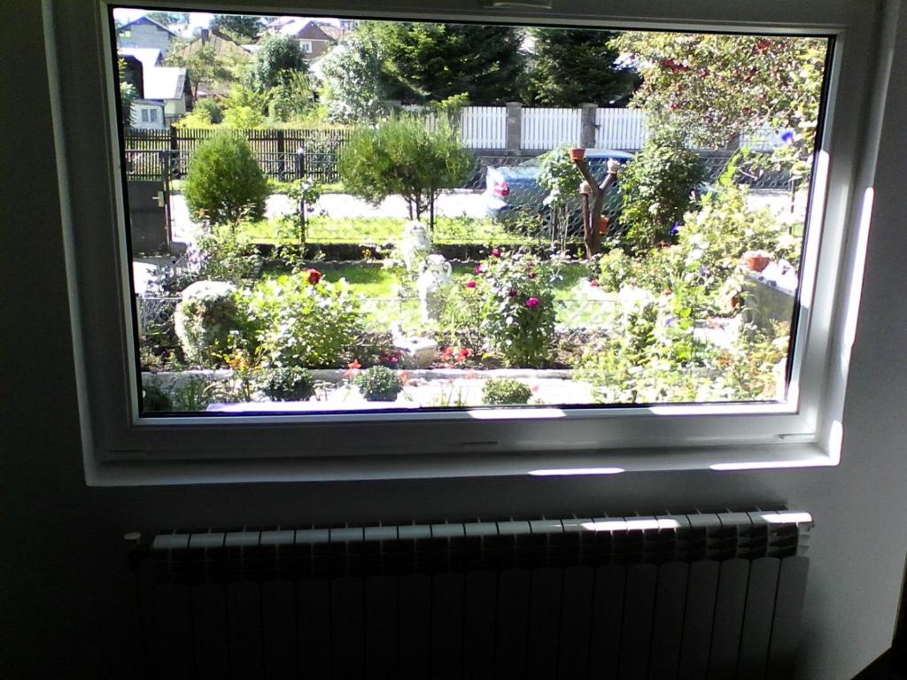 ventana con vistas al jardín en Buşteni House, en Buşteni