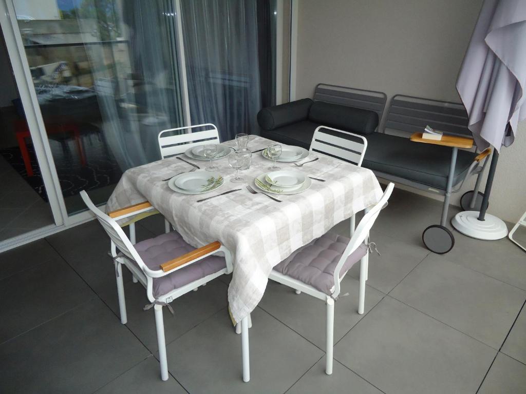 een eettafel met een tafelkleed en stoelen bij appartement in Calvi