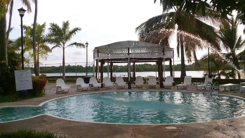 a swimming pool with chairs and a gazebo at Hotel Marina San Blas in San Blas