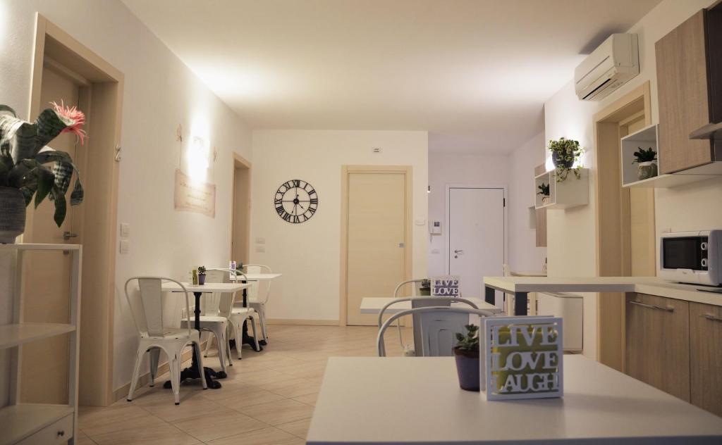 una cocina con mesas y sillas y un reloj en la pared en Il Sorriso, en Negrar