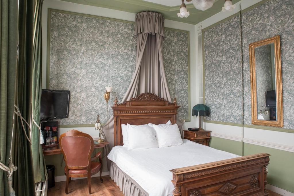 een slaapkamer met een bed en een stoel bij Hotel Fidder - Patrick's Whisky Bar in Zwolle