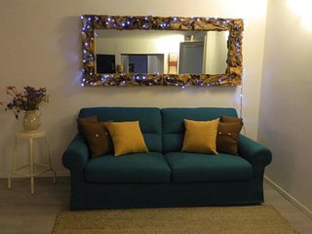 niebieską kanapę w salonie z lustrem w obiekcie Appartamento Ninì Short lets w mieście Napoli
