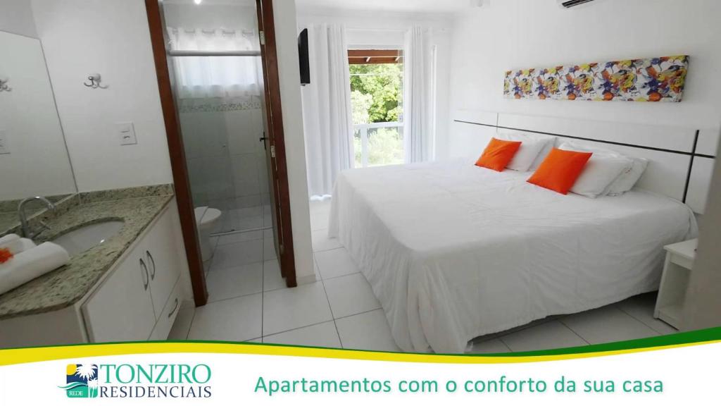 Habitación blanca con cama y baño. en apartamento monte hebron, en Porto Seguro