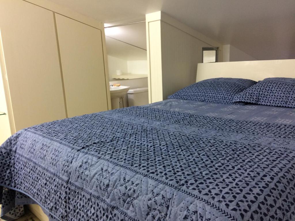 a bedroom with a bed with a blue comforter at CONDOMÍNIO IMPERIAL, PRAIA DO FRANCÊS in Praia do Frances