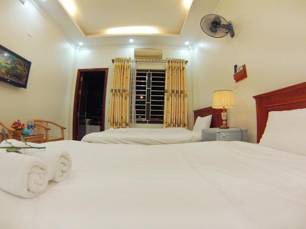 a bedroom with two white beds and a window at ninh binh friendly hotel in Ninh Binh