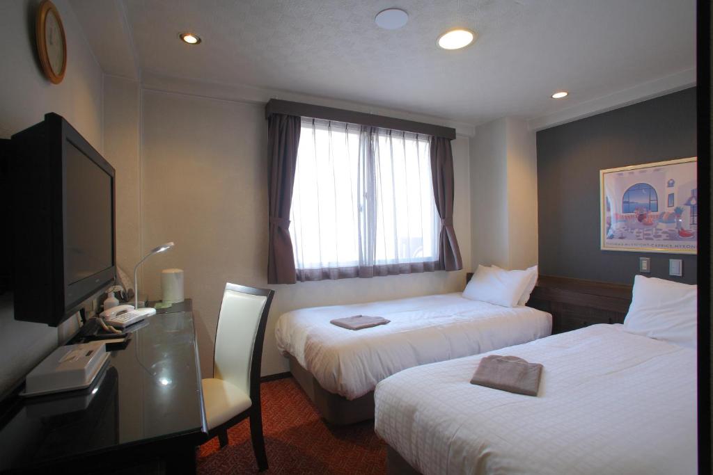 Postel nebo postele na pokoji v ubytování Shimizu City Hotel