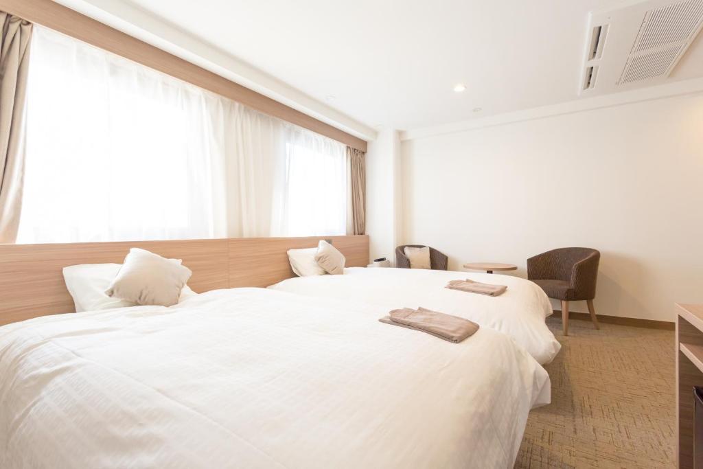 Postel nebo postele na pokoji v ubytování Shimizu City Hotel