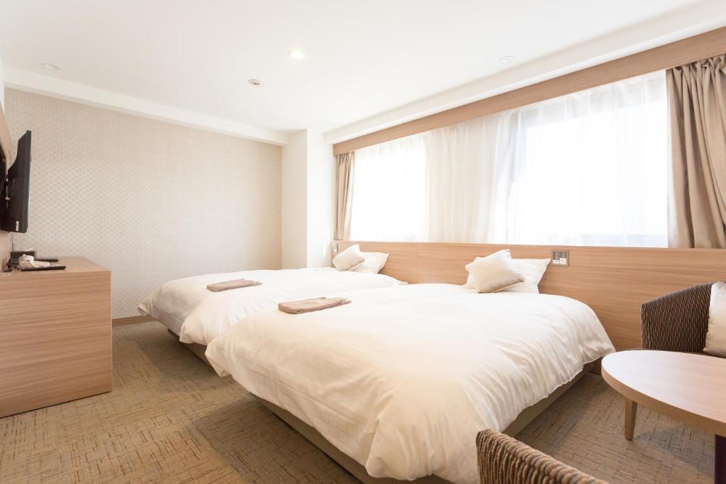Postel nebo postele na pokoji v ubytování Shimizu City Hotel