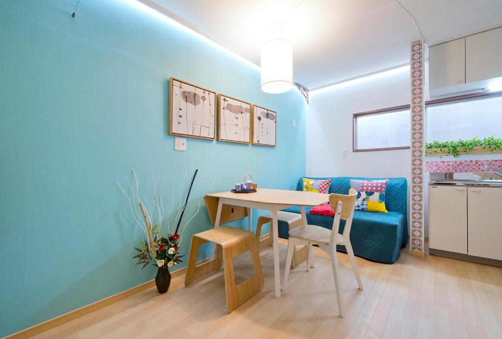 ein Wohnzimmer mit einem Tisch und einer blauen Wand in der Unterkunft Lucy's House横浜中華街 House3 in Yokohama