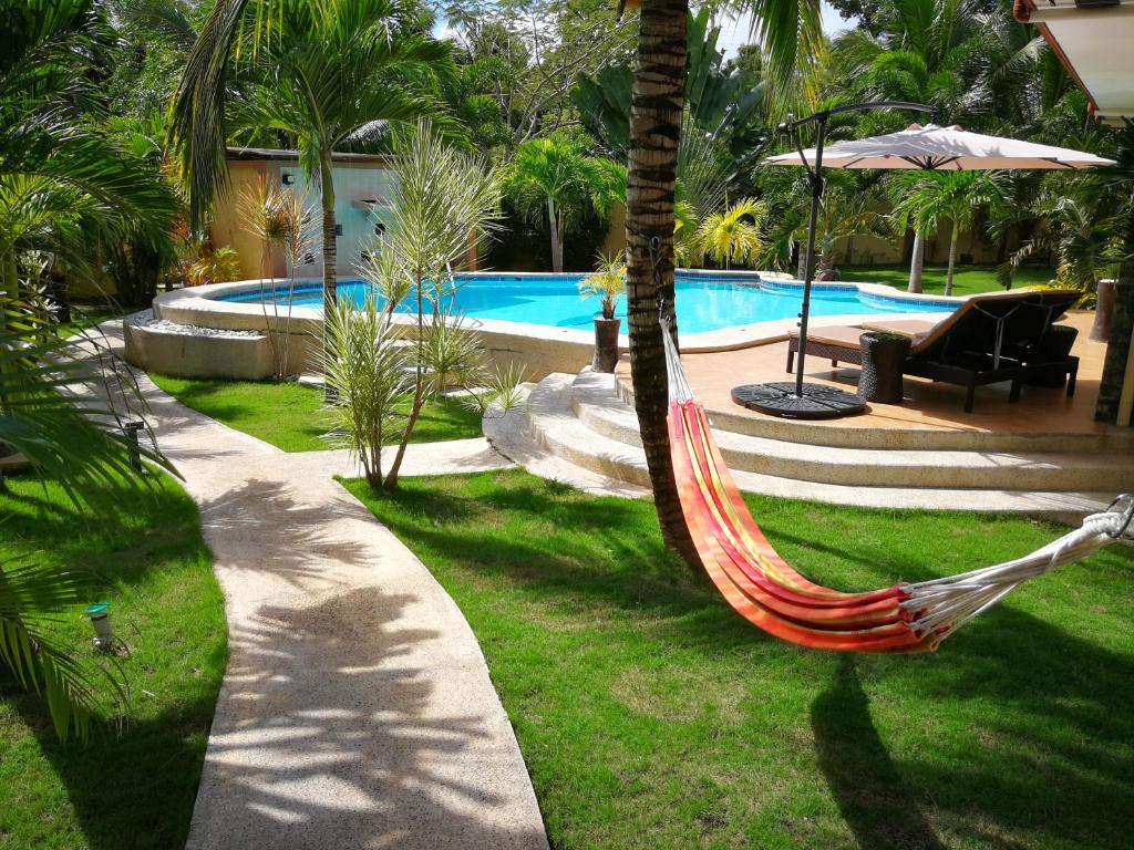 a hammock in a yard next to a swimming pool at Casa Cataleya Bohol Self-service Apartments in Panglao Island