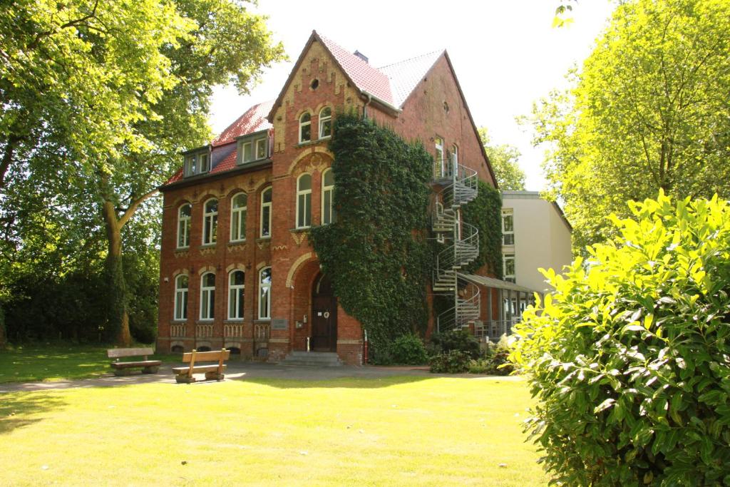 un gran edificio de ladrillo con hiedra creciendo en él en Gästehaus Alte Schule, en Recklinghausen