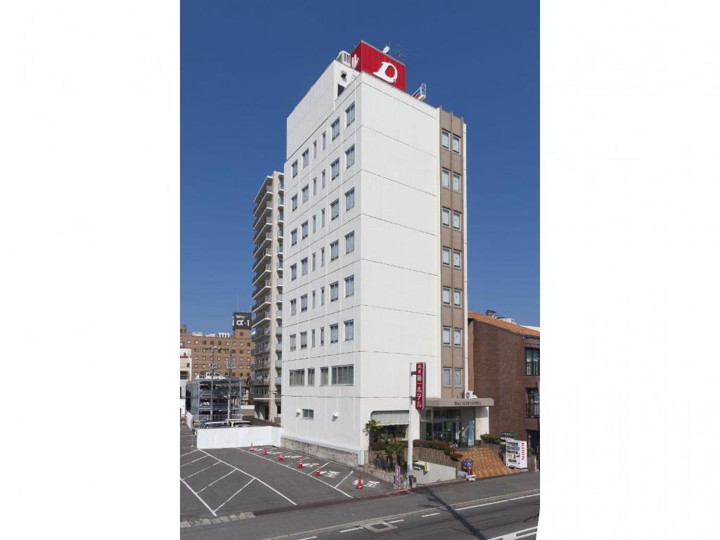 a white building with a red roof on top of it at Onomichi Daiichi Hotel in Onomichi