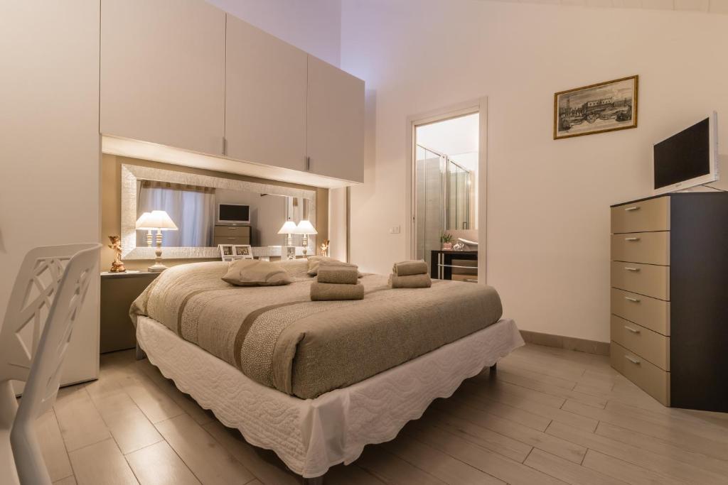 ヴェネツィアにあるCà Lessiaのベッドルーム1室(ベッド1台、ドレッサー付)、キッチンが備わります。