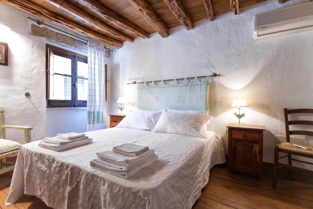 a bedroom with a white bed with towels on it at Antiche Case in Pietra in Baunei
