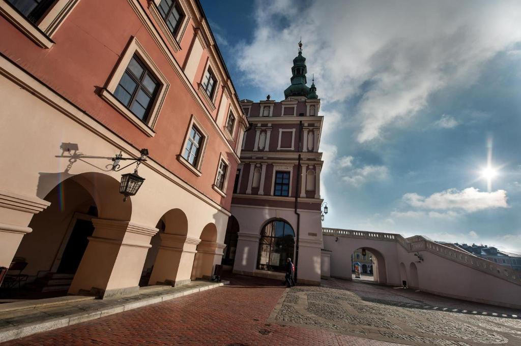 un gran edificio con una torre de reloj a lo lejos en Hotel Zamojski, en Zamość