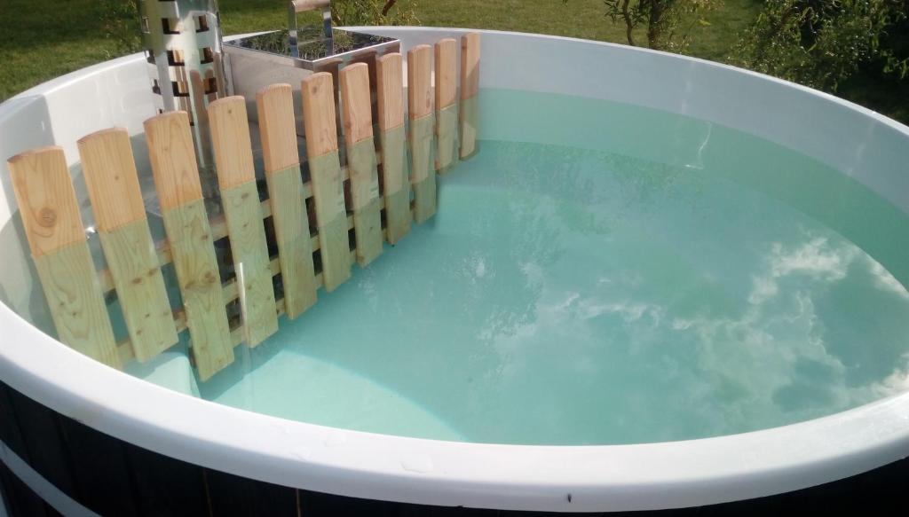 a bath tub with a wooden fence around it at Stilove Wydmy in Sasino