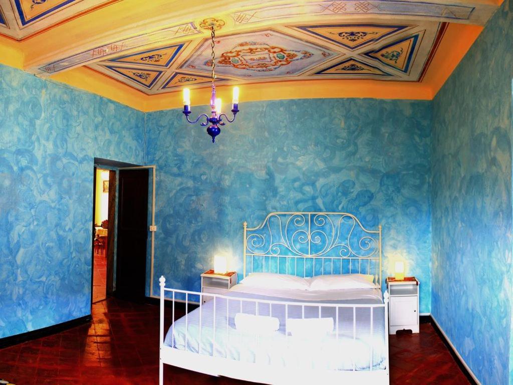 - une chambre avec un lit aux murs bleus et un lustre dans l'établissement Appartamento di Prestigio- Cà da Lina - Deiva Marina, à Deiva Marina