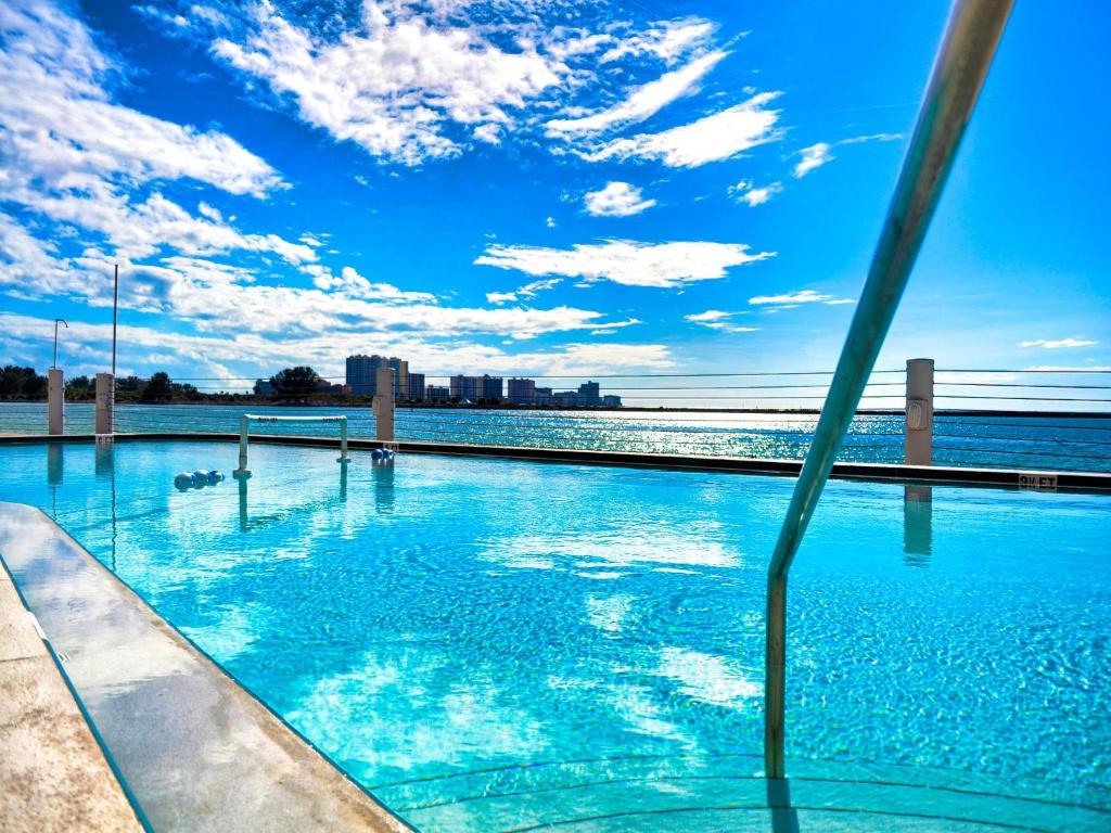 a swimming pool next to the ocean with a blue sky at 440 West Condos 408N in Clearwater Beach