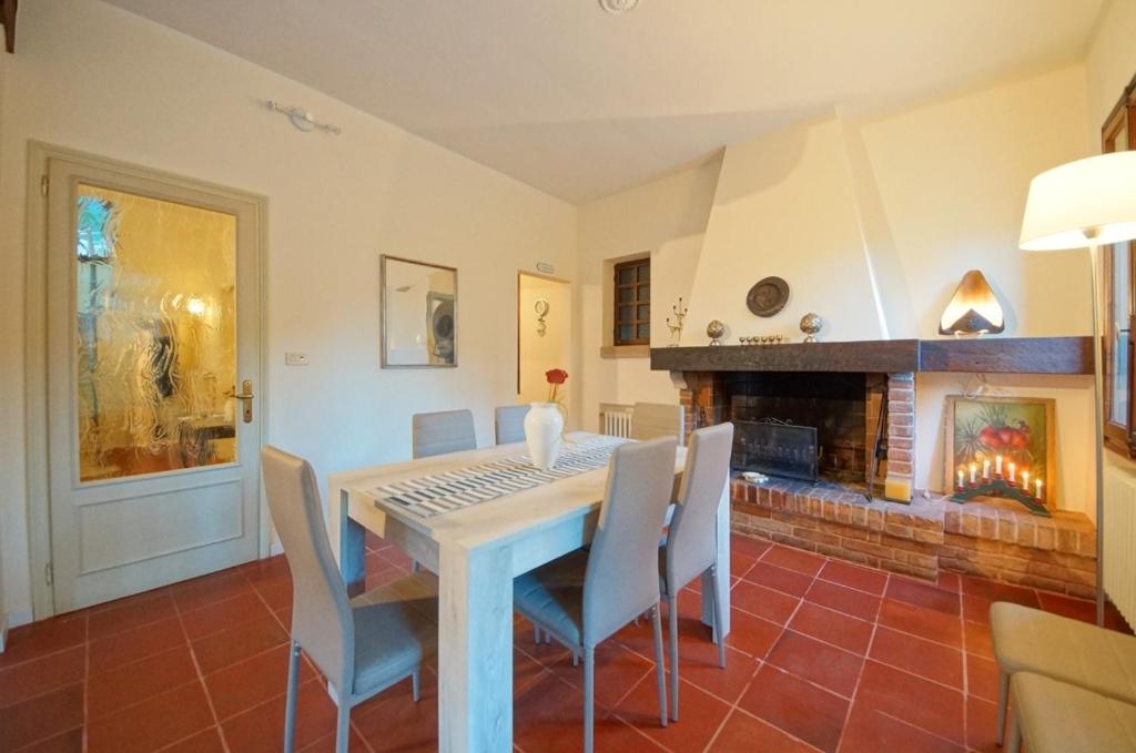 una sala da pranzo con tavolo, sedie e camino di Treviso Casa Magnolie wi-fi a Treviso