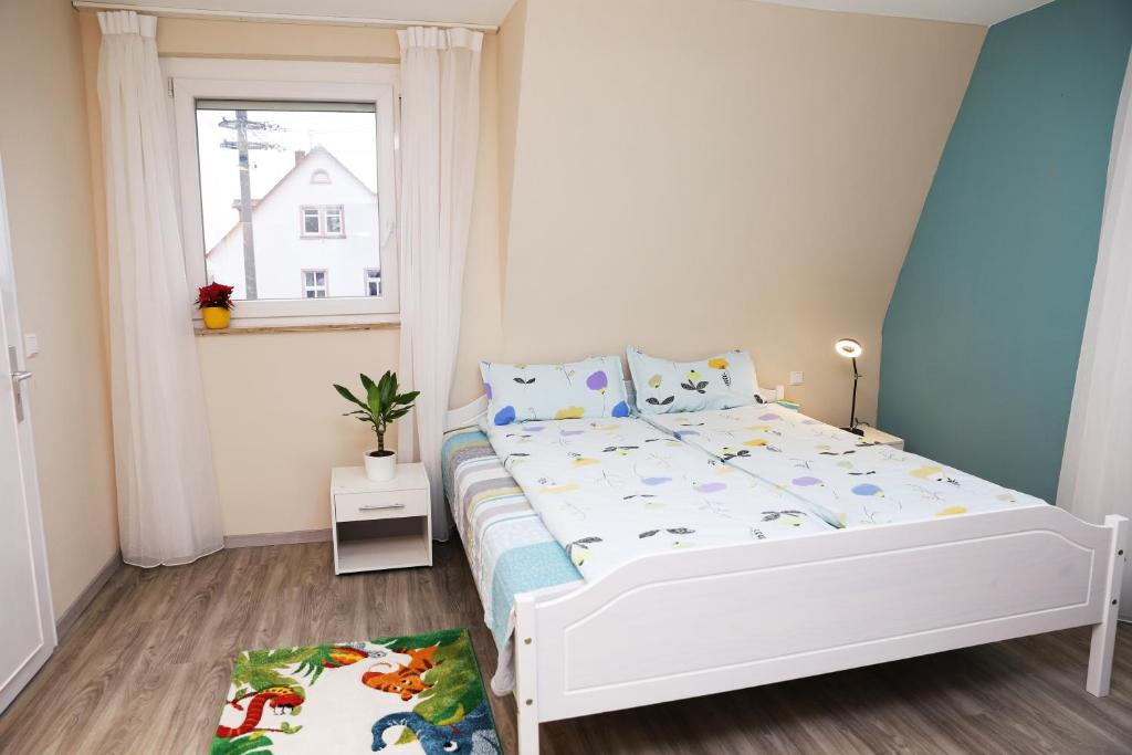 um pequeno quarto com uma cama branca e uma janela em Charlotte Flat Heidelberg em Dossenheim