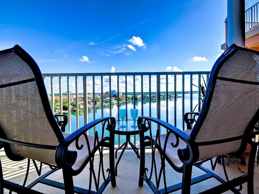 Dos sillas y una mesa en un balcón con vista al mar. en Harborview Grande 705, en Clearwater Beach