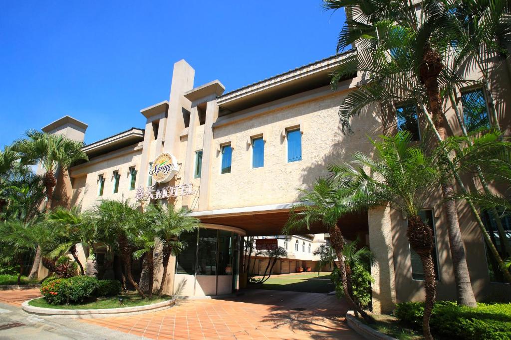 a building with palm trees in front of it at Spring Hotel in Taichung