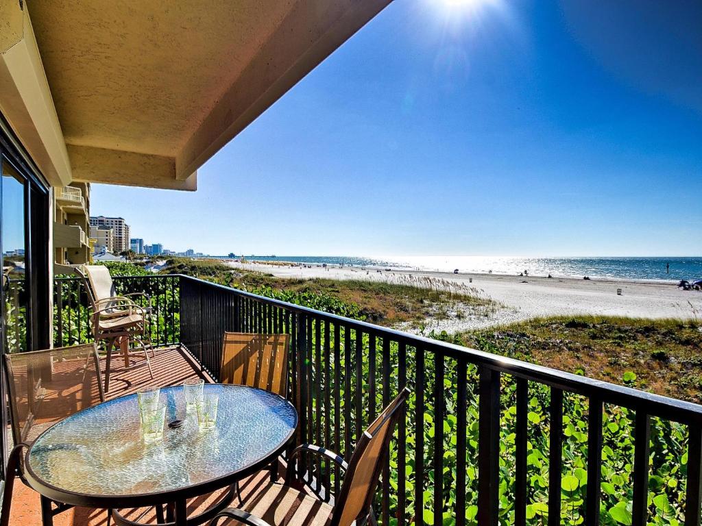 a balcony with a table and chairs and the beach at Surfside Condos 204 in Clearwater Beach