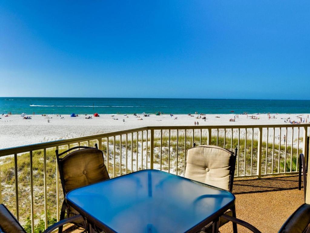 un tavolo blu e 2 sedie su un balcone con vista sulla spiaggia di Villas of Clearwater Beach 8A a Clearwater Beach