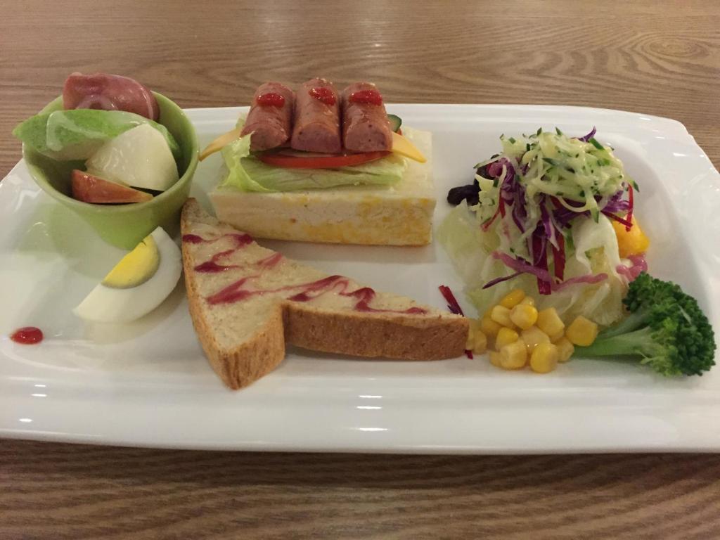 a plate of food with a sandwich and a salad at NL Concept Hotel in Kaohsiung