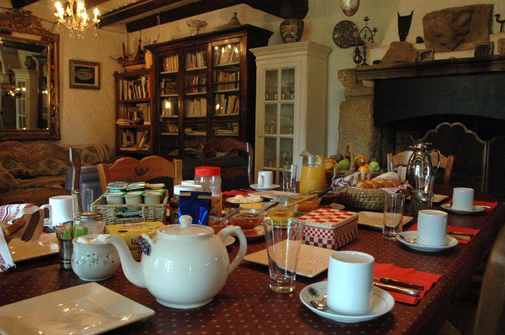 Ecuries Sainte Croix في قرقشونة: طاولة غرفة الطعام مع وعاء الشاي والأطباق عليها