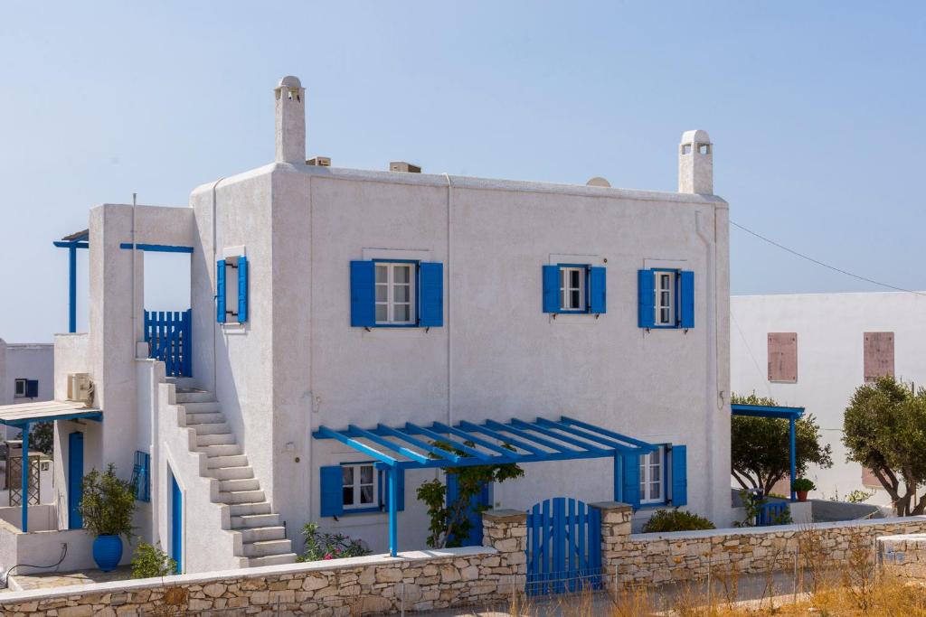 un edificio azul y blanco con ventanas y escaleras azules en Villa Mariliza, en Piso Livadi