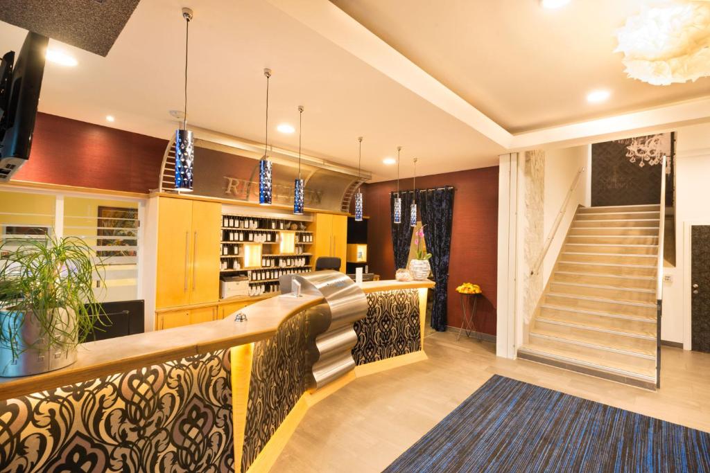 a living room with a staircase and a kitchen at Hotel City in Villach