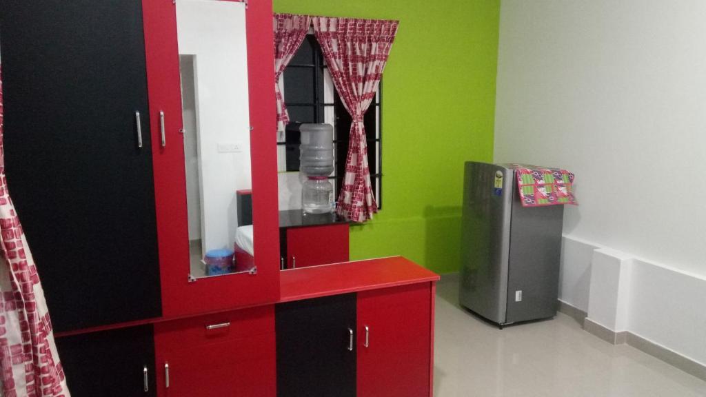 um quarto com um armário vermelho e um frigorífico em Cukoos Nest em Cochin