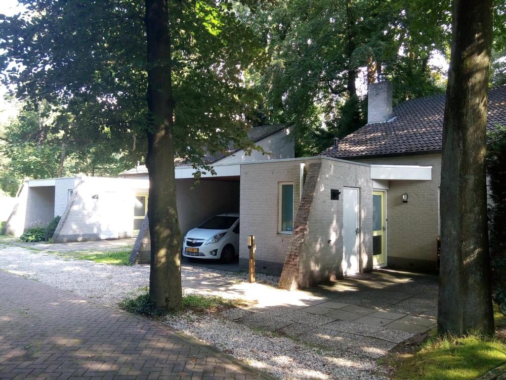 un coche aparcado frente a una casa en Bospark Nuwenspete, en Nunspeet