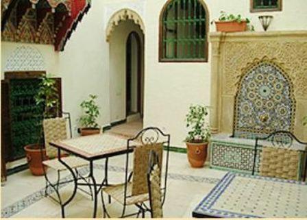 eine Terrasse mit einem Tisch und Stühlen in einem Gebäude in der Unterkunft Dar Aida in Rabat