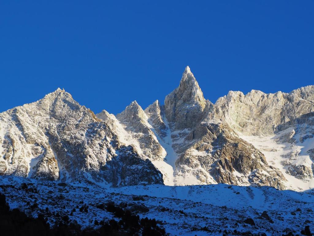 a snow covered mountain range with a blue sky at Aiguille de La Tza in Arolla
