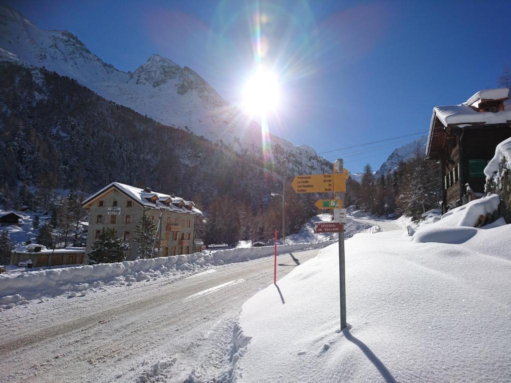 a snow covered street with the sun shining on a mountain at Aiguille de La Tza in Arolla