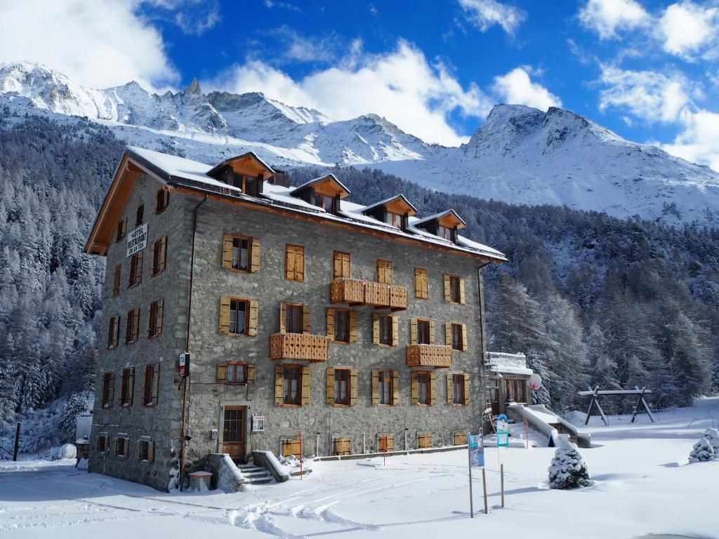 a large building in the snow with mountains in the background at Aiguille de La Tza in Arolla