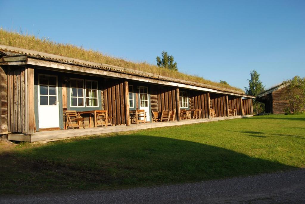 a large wooden cabin with a grass roof at Dala Wärdshus in Rättvik