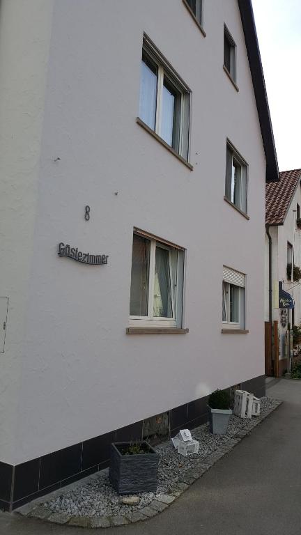 a white building with a sign on the side of it at Gästezimmer Fuchs in Ramsthal