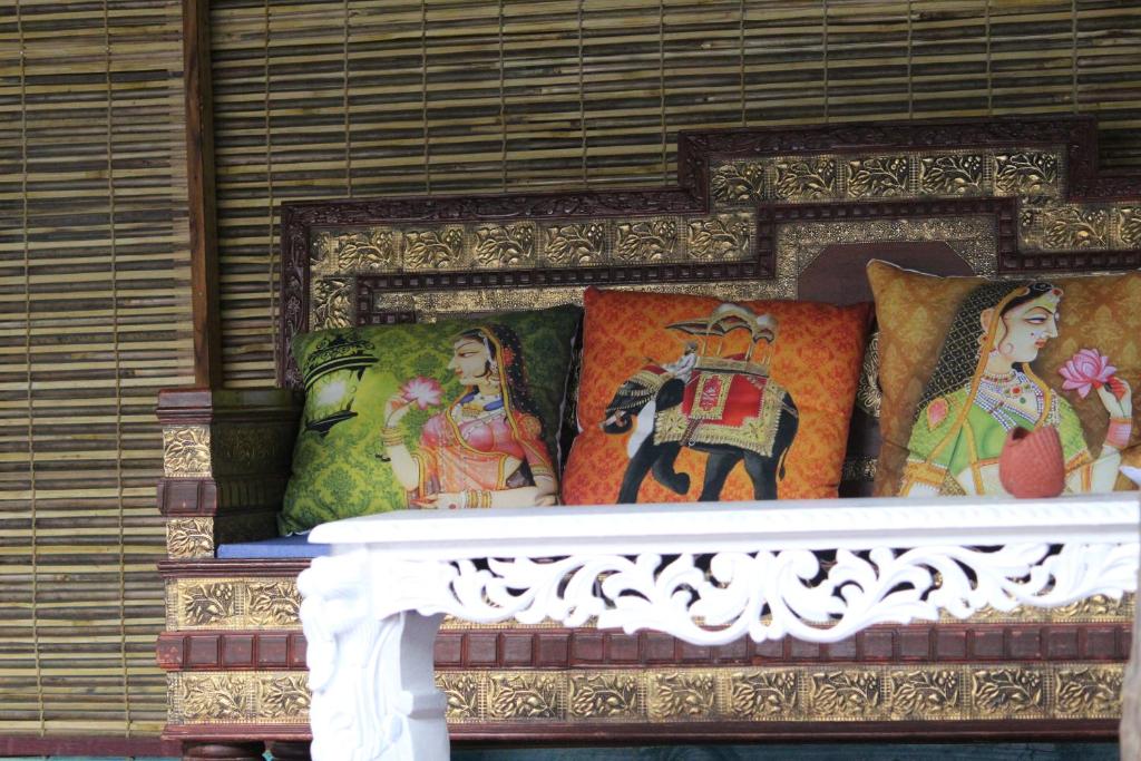 a table with pillows and paintings on it at Patnem Dwarka in Patnem