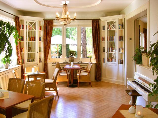 a living room with a table and chairs and a piano at Cafe´Seestrasse in Magdeburg